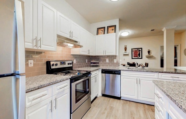 a kitchen with white cabinets and stainless steel appliances