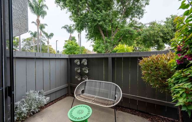 a small patio with a chair and a privacy fence