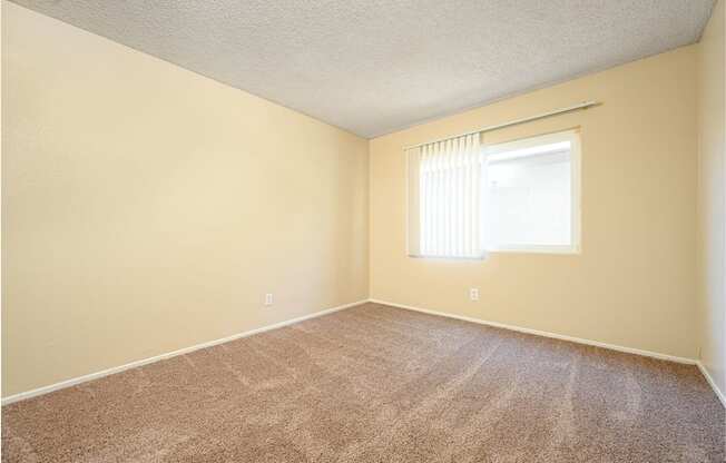 a bedroom with a window and a carpeted floor at Oak Terrace Senior Apts, California