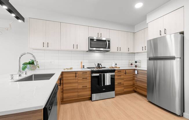 a kitchen with white countertops and wooden cabinets at Ion Town Center, Shoreline, WA