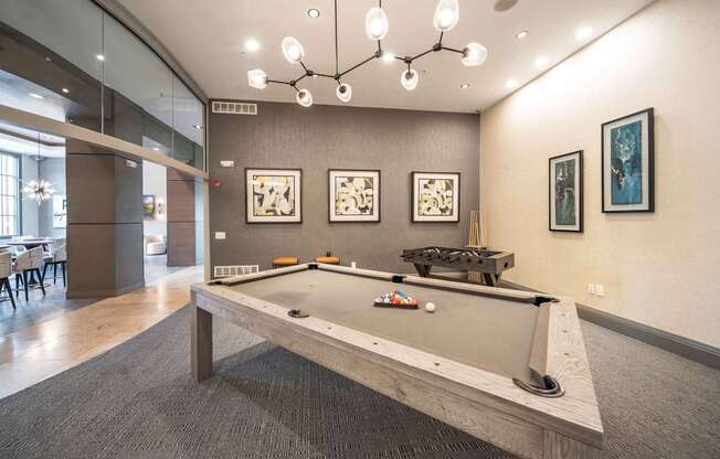 A pool table in a room with a grey carpet at Harbor Pointe Apartments, Bayonne