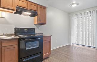 A kitchen with wooden cabinets and a black stove top oven.