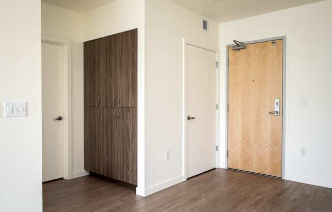 an empty room with a wooden door and a closet