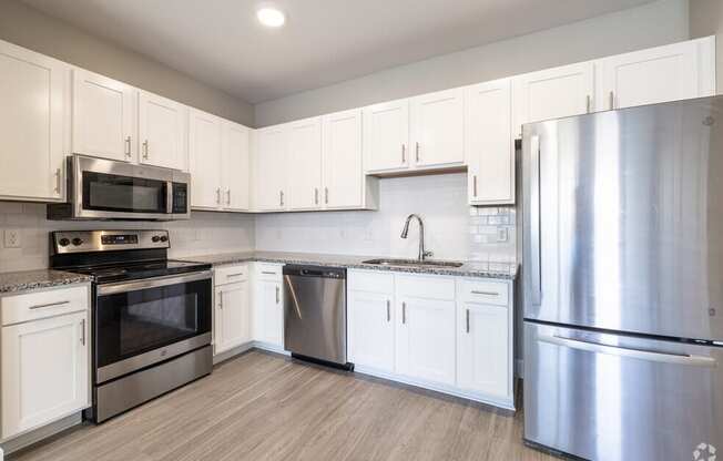 a kitchen with stainless steel appliances and white cabinets