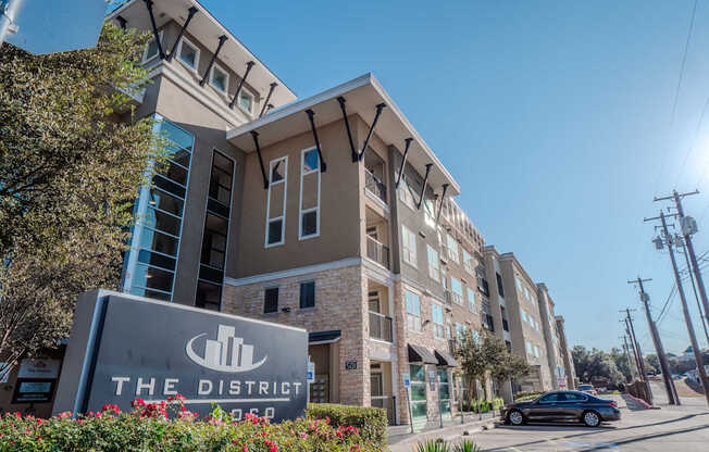 an apartment building with a sign for the district in front of it