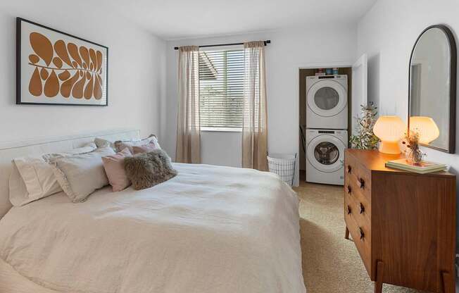 A bedroom with a large bed and a wooden nightstand.