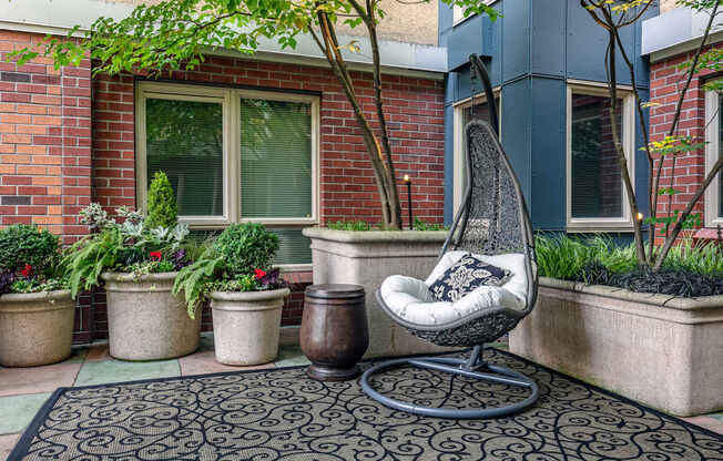 A chair sits on a patio with a brick wall behind it.