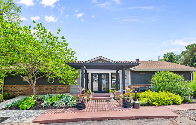 the front of a house with a walkway and potted plants