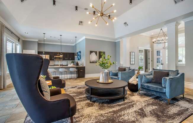 a living room with blue furniture and a chandelier at Reserve by the Lake, Houston