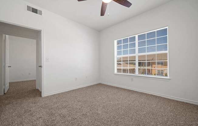 A room with a window and a ceiling fan.