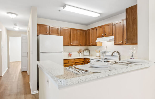 a kitchen with white counter tops and wooden cabinets