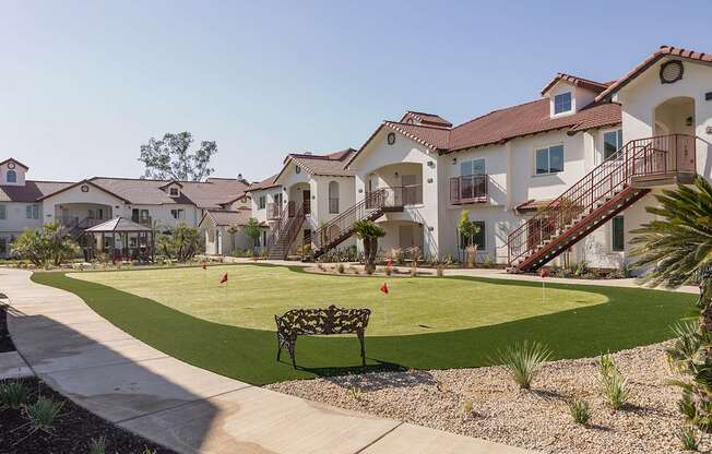 A row of houses with a green lawn in front.