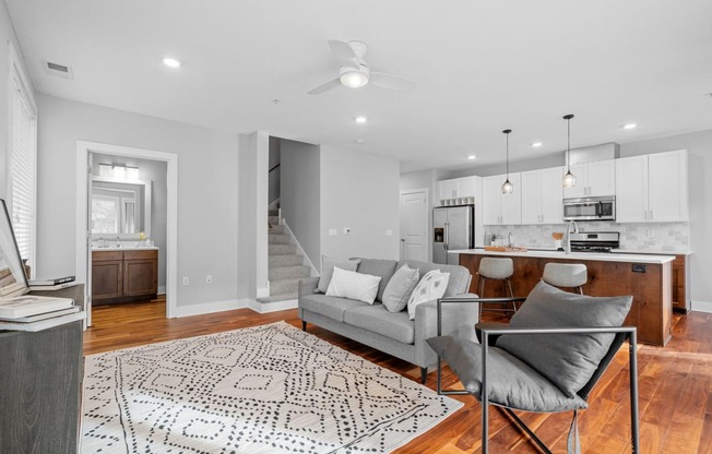 a living room with a couch and a chair and a kitchen