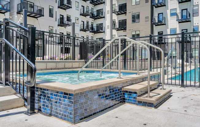 A small pool with a metal railing and steps leading to it.