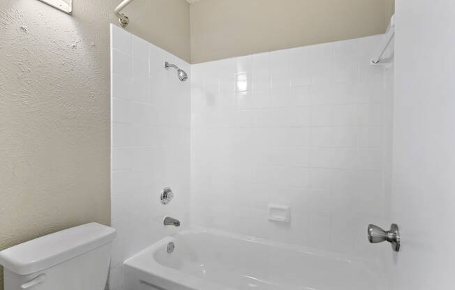 a bathroom with a white tub and a white toilet