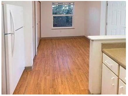A kitchen with white cabinets and a white fridge.