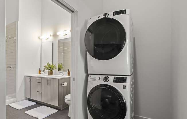 a white washer and dryer in a small bathroom