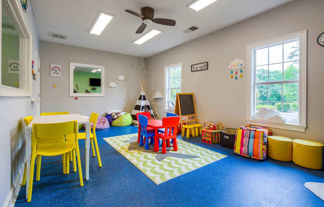 a childs play area with a table and chairs and a television