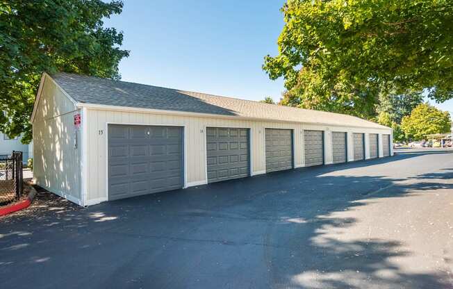 A long white building with a grey roof and a black fence.