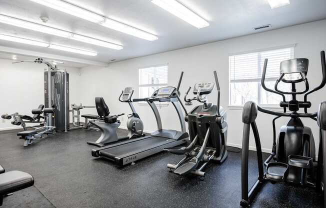 A gym with treadmills, elliptical machines, and other exercise equipment.