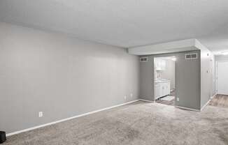 an empty living room with carpeting and a white bathroom
