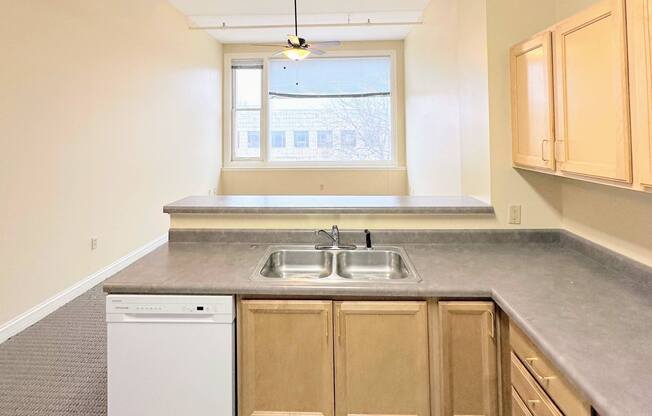 an empty kitchen with a sink and a window