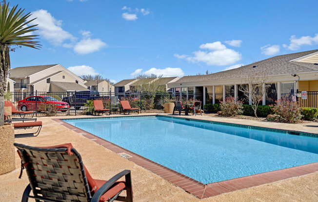 A sunny outdoor pool area at Acacia Park featuring a sparkling swimming pool, comfortable lounge seating, open sightlines, and a relaxed community vibe ideal for warm-weather enjoyment.
