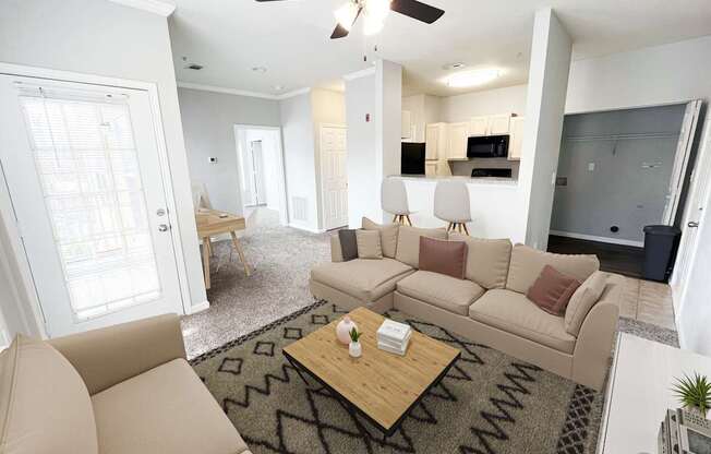 A living room with a beige couch and a coffee table.