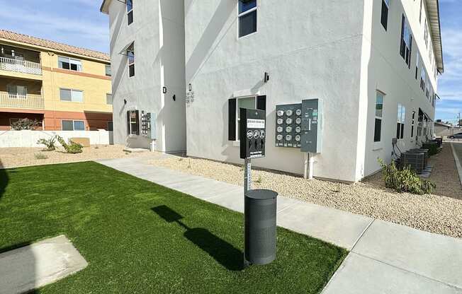 a parking meter in the grass in front of a building