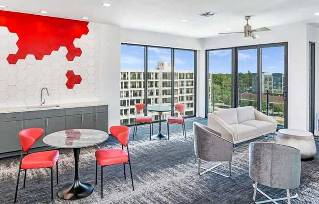 A modern living room with a round table and chairs, a sofa, and a red abstract wall art.