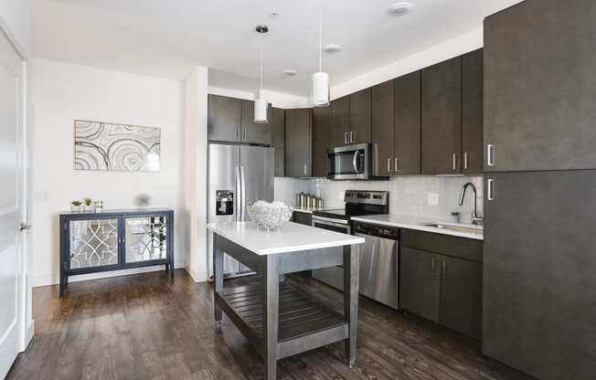 a kitchen with stainless steel appliances and a white island in the middle