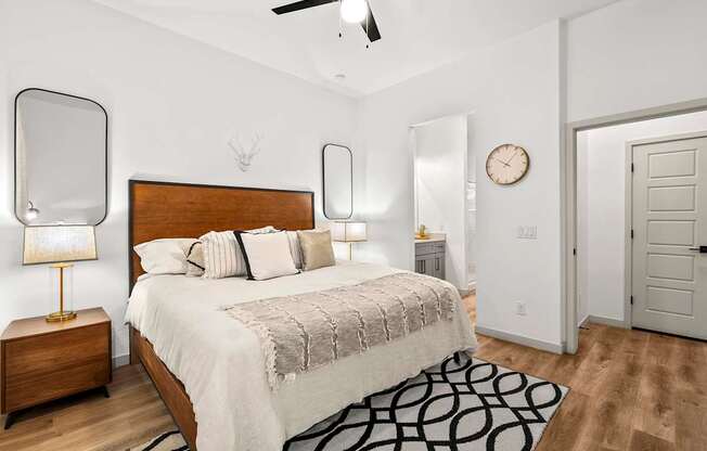 A bedroom with a bed, nightstands, and a rug.