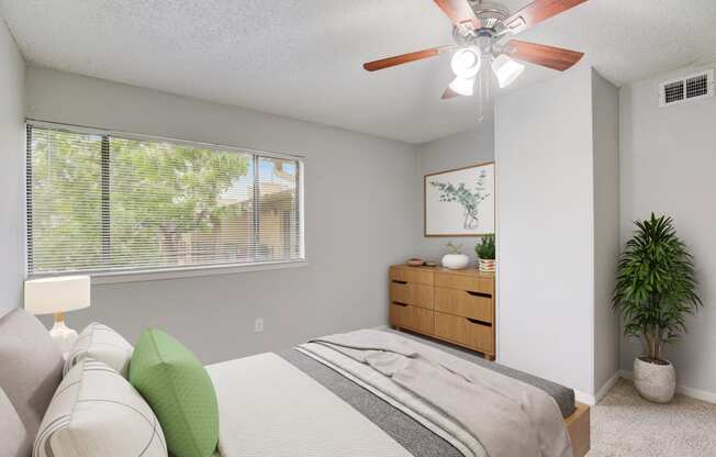 a bedroom with a bed and a ceiling fan