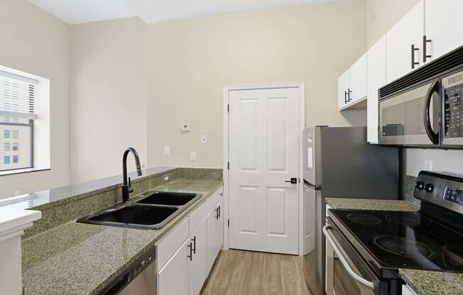 A kitchen with granite countertops and stainless steel appliances.