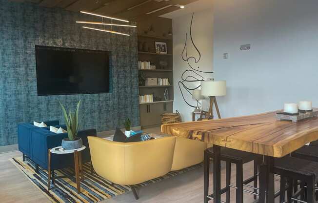 a living room with a tv and a wooden table at Link Apartments® Canvas, Atlanta, 30312