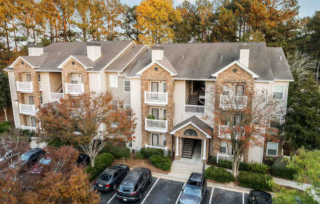 the view of an apartment building with cars parked in front of it