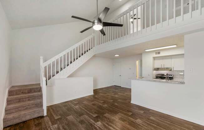 Model living room with stairs to second level at Lake Tivoli Apartments in Kissimmee, FL