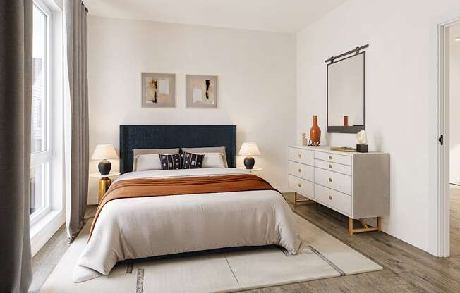 A bedroom with a large bed, a dresser, and a mirror.