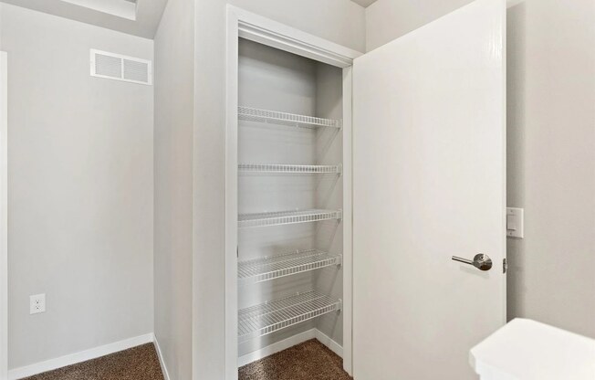a pantry/closet with built-in shelving in a home at Muskego School Apartments