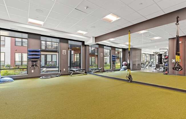 A gym with a yellow floor and various exercise equipment.