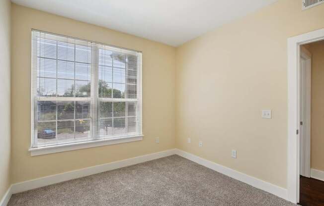 A room with a window and a car parked outside.