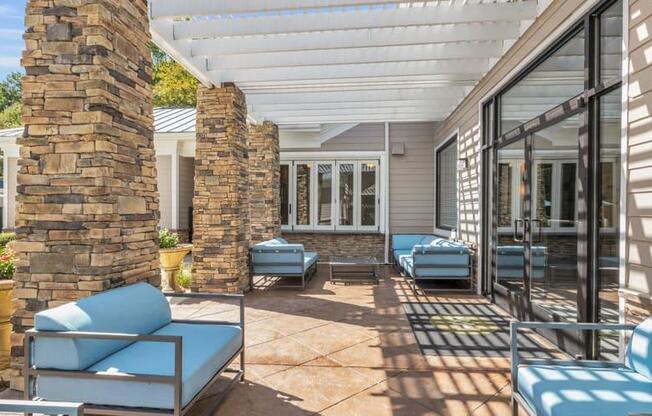 a covered patio with blue chairs and a stone wall at Marina Point, Chattanooga, TN 37415