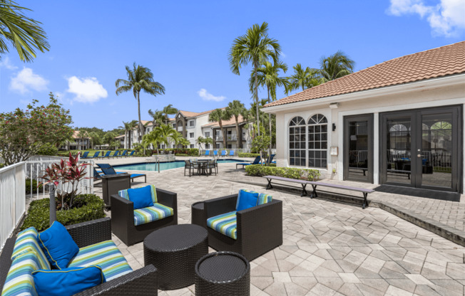 a patio with chairs and tables and a swimming pool