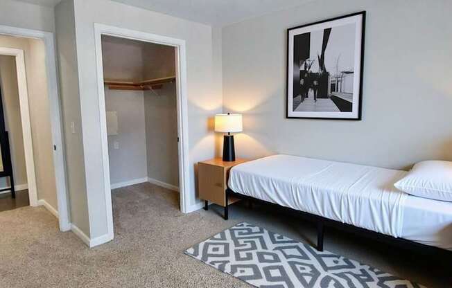 A bedroom with a bed, two lamps, and a framed picture on the wall.