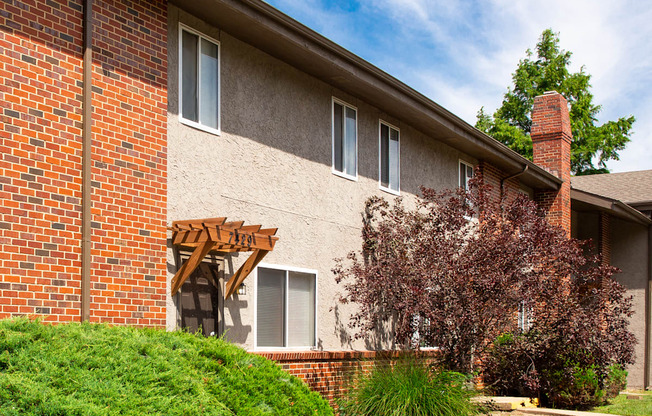 A red brick building with a white window and a brown roof.