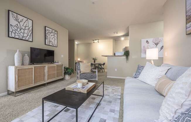 A living room with a white couch and a black coffee table.