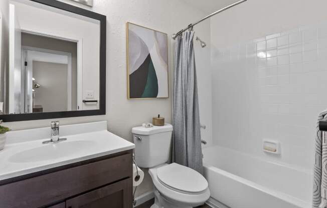 A bathroom with a toilet, sink, and bathtub.