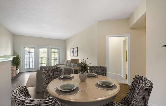 A dining room with a round table surrounded by chairs.