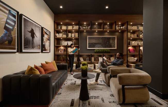 A man is sitting on a couch in a room with a coffee table in front of him.