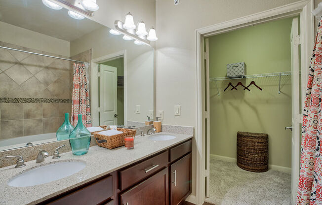 a bathroom with two sinks and a large mirror at Platinum Castle Hills, Lewisville, Texas